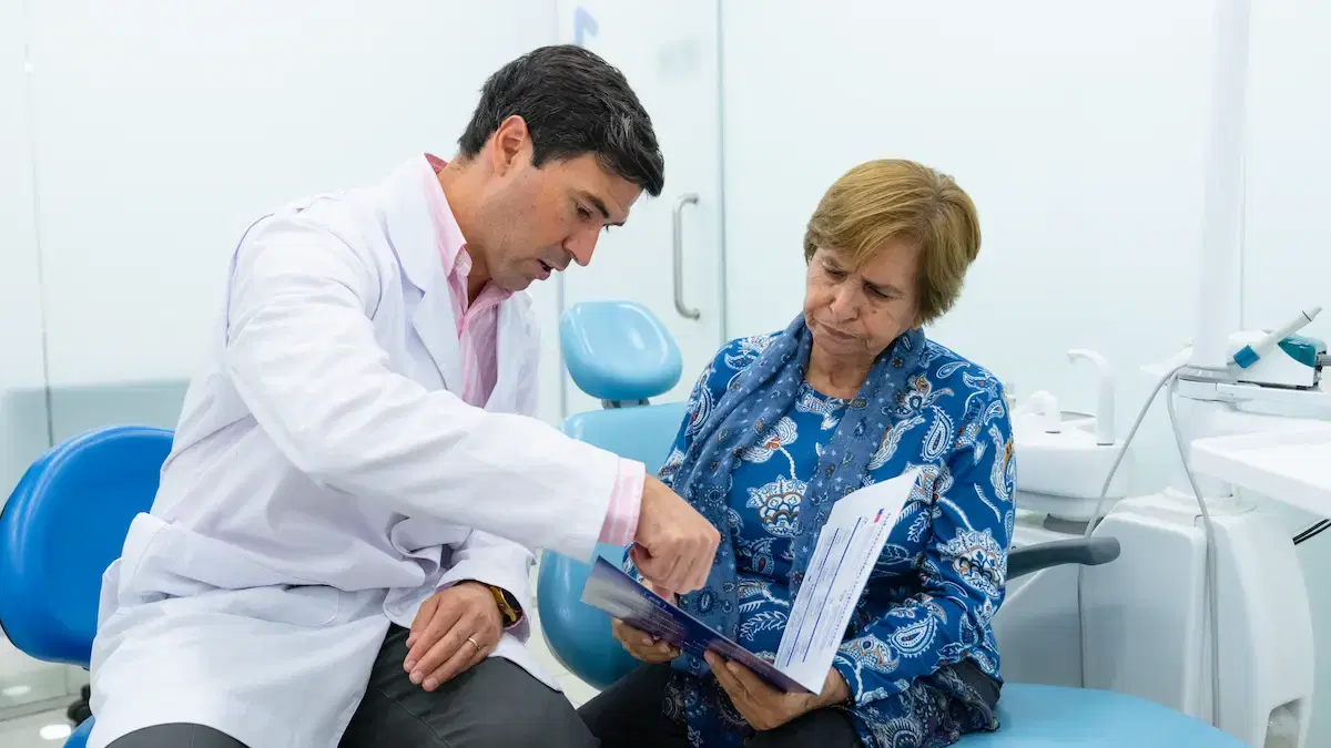 Dentista de Dentistas por Chile revisando con una paciente los documentos de su tratamiento en el box
